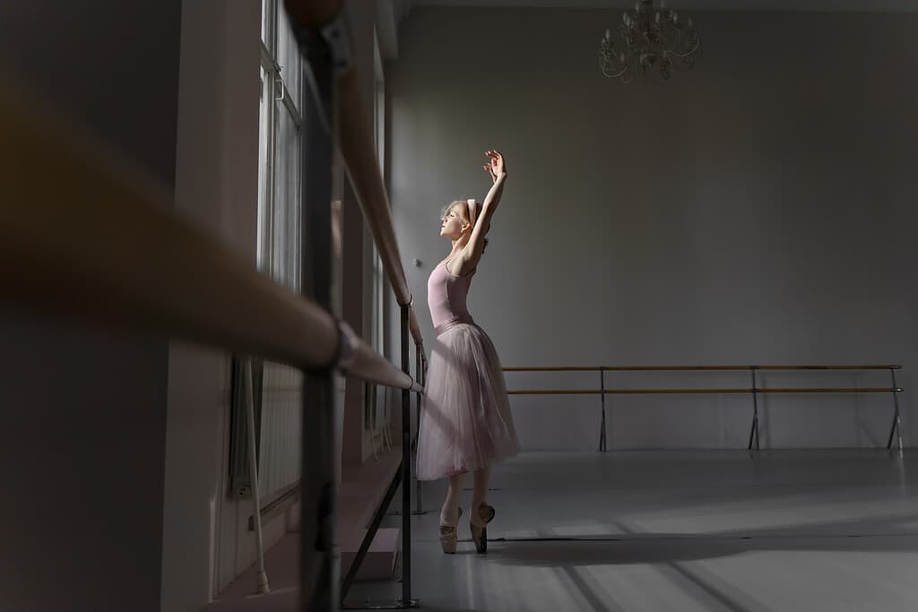 Ballerina in a purple outfit dancing at the Barre during a ballet audition