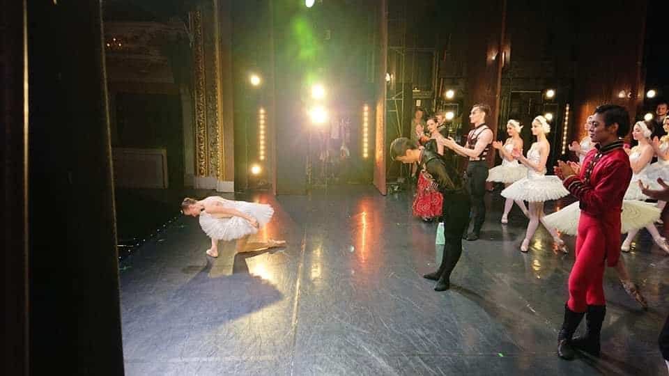 Lead ballerina bowing on stage after ballet performance