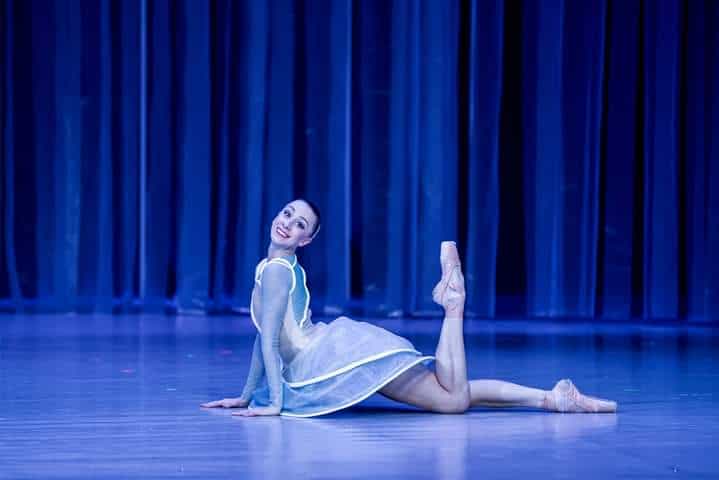 Professional Ballerina performing on stage under blue lights