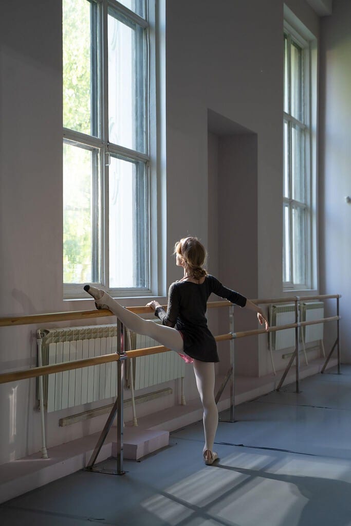 Female dancer lifting their leg off the ballet barre