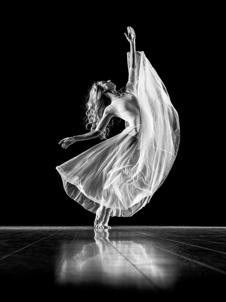 Black and white photo of a professional dancer on stage fully immersed in the performance