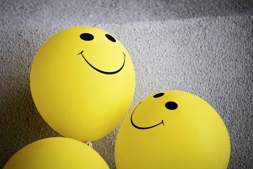 Three yellow balloons with smiley faces