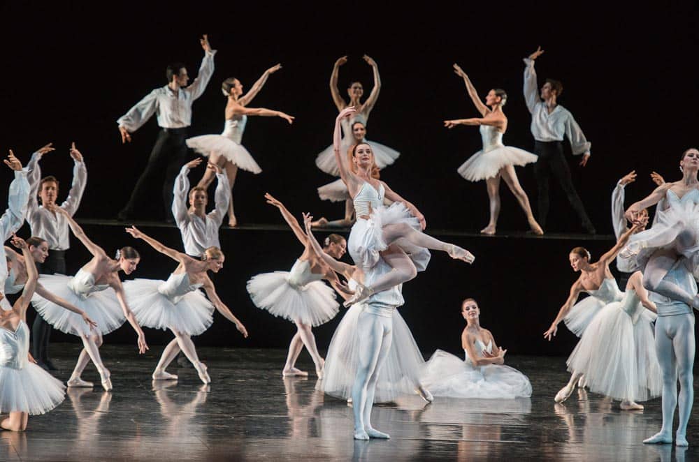 Dancers on stage in white costumes performing the neoclassical ballet Suite en Blanc