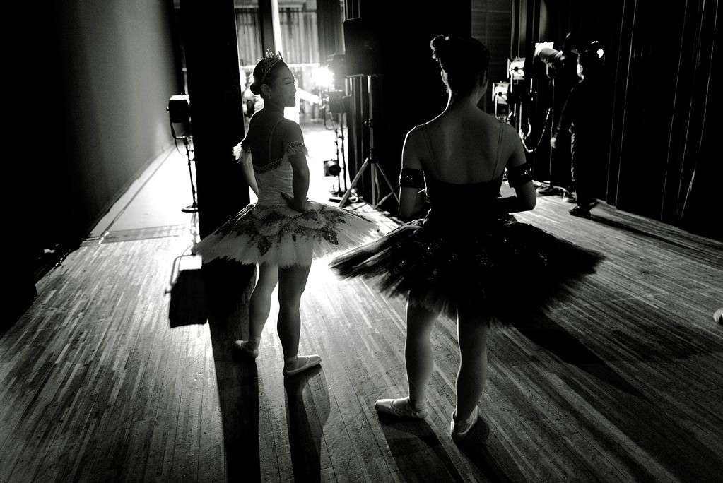 Two ballerinas wearing a ballet tutu on the side of the stage