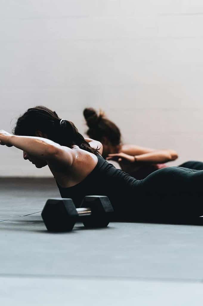 Female performing back strengthening exercise on the floor