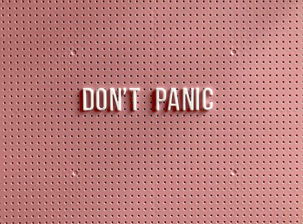 White Don't Panic Text against a pink background