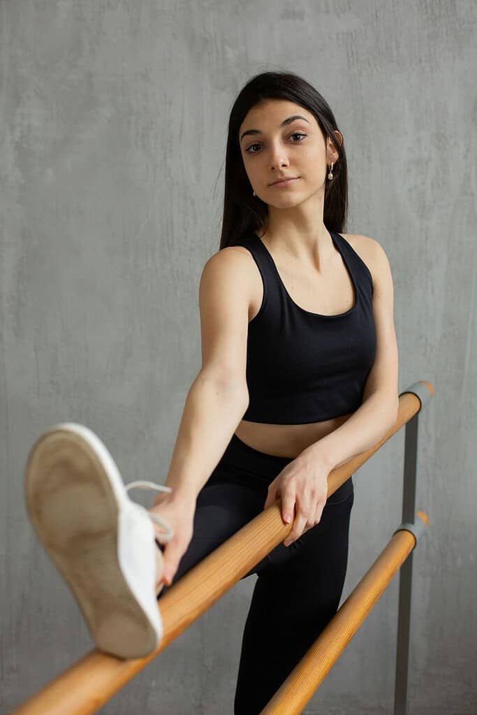 Female dancer stretching her leg on a double ballet barre