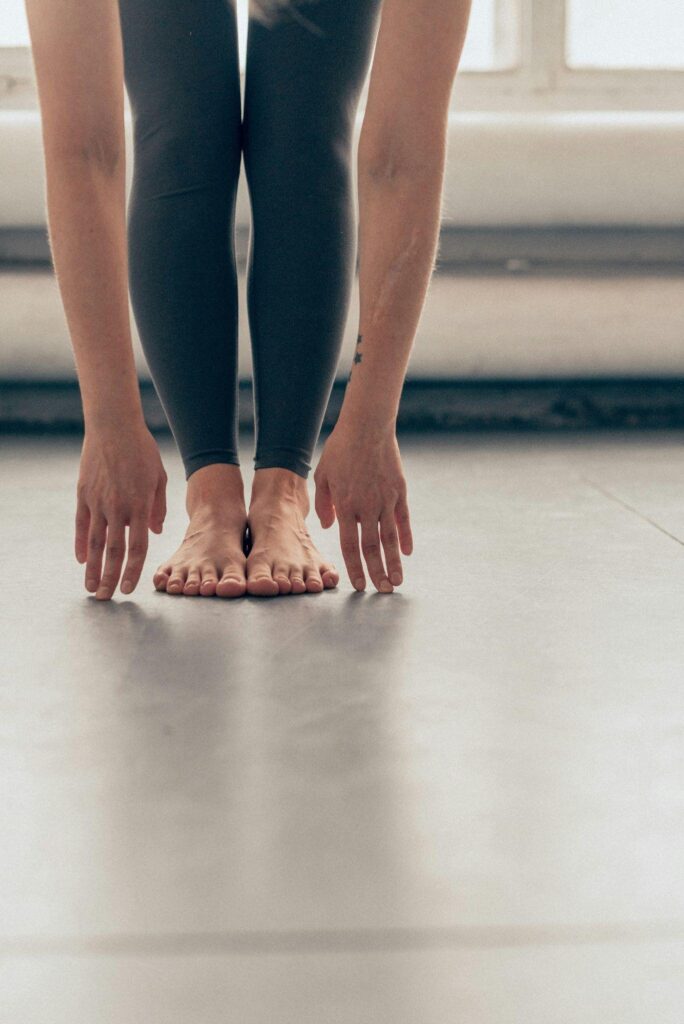 Dancer stretching her hands to touch her toes while standing up