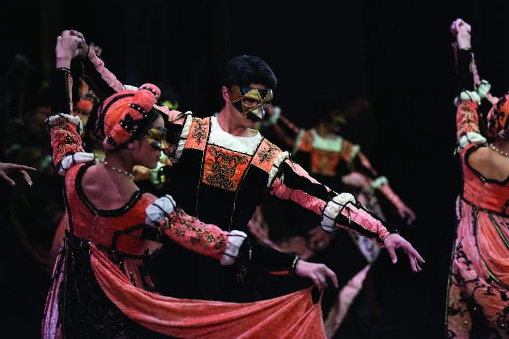 Dancers in costume and masks at the Capulet Ball