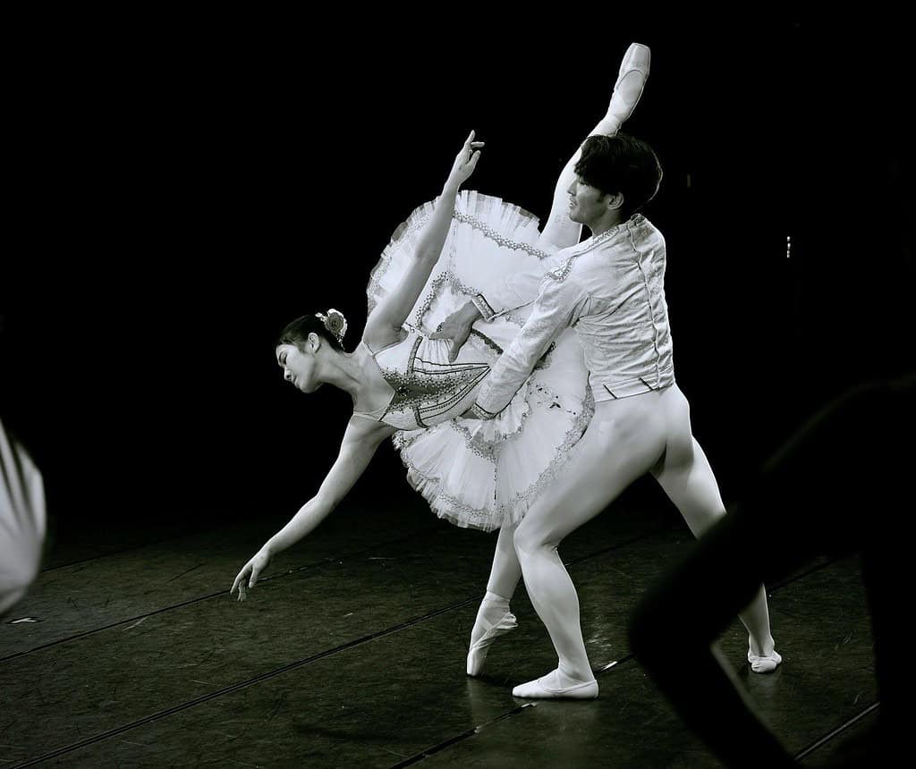 Female dancer in fourth arabesque with male partner supporting