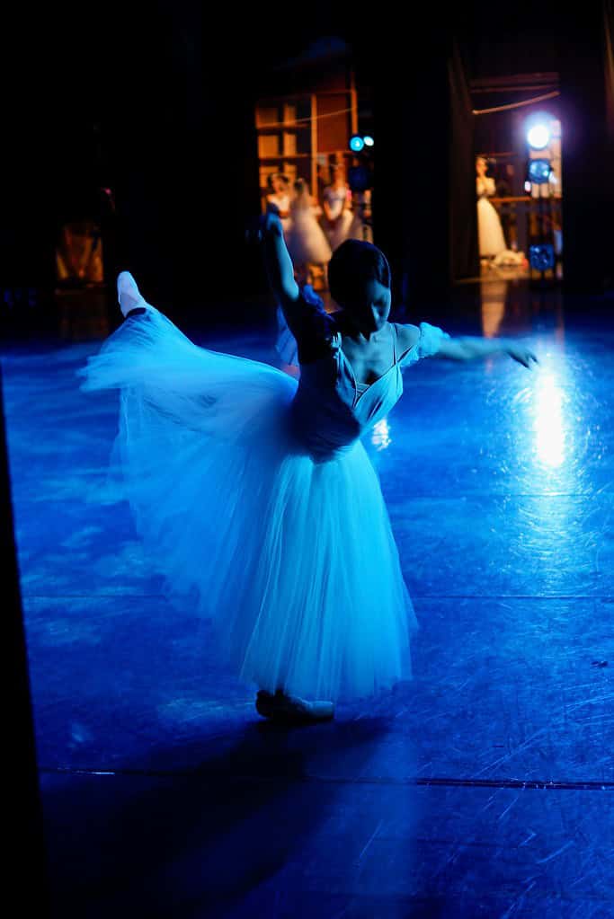 Principal dancer on stage under blue lights