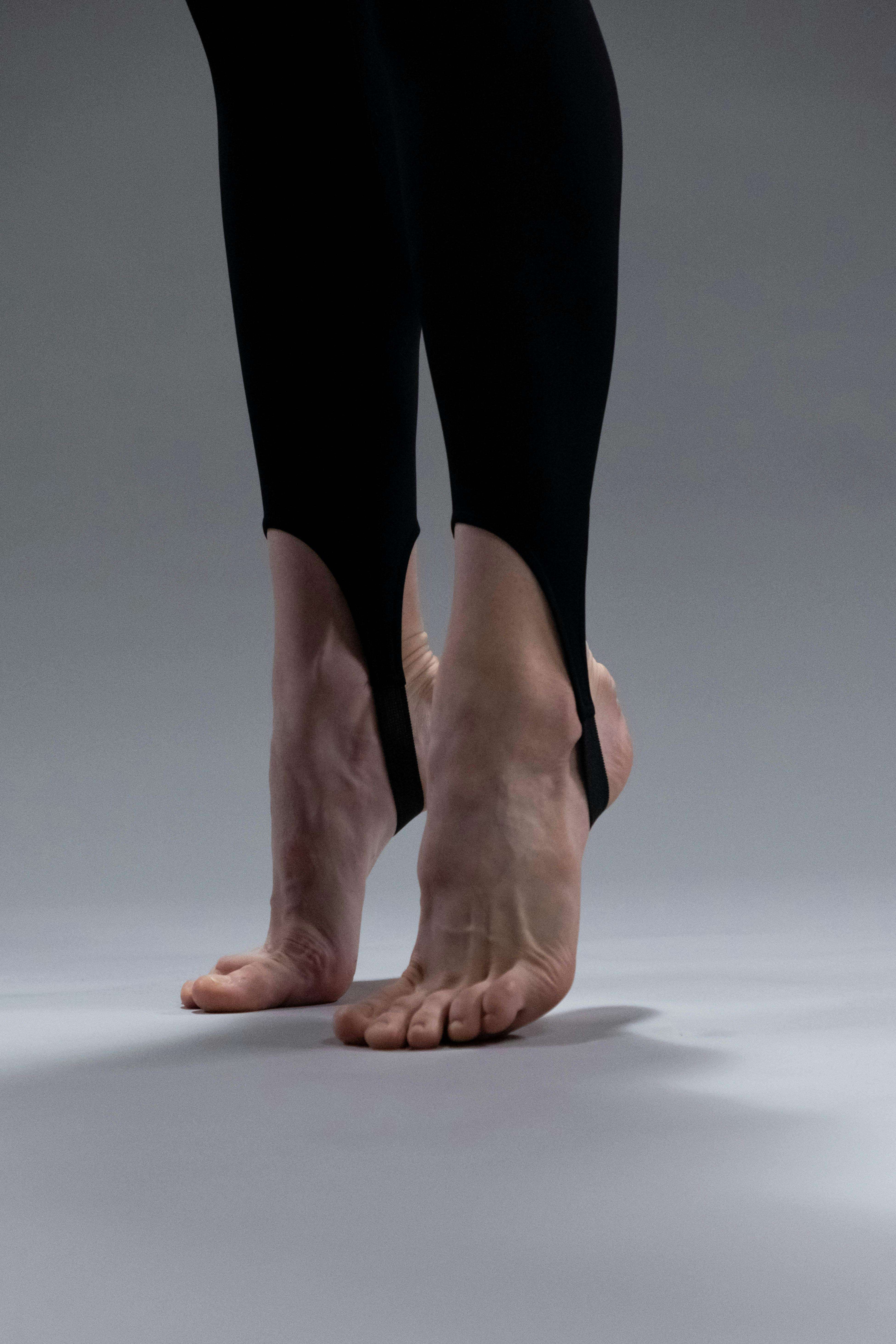 Female ballerina practicing demi pointe in black tights