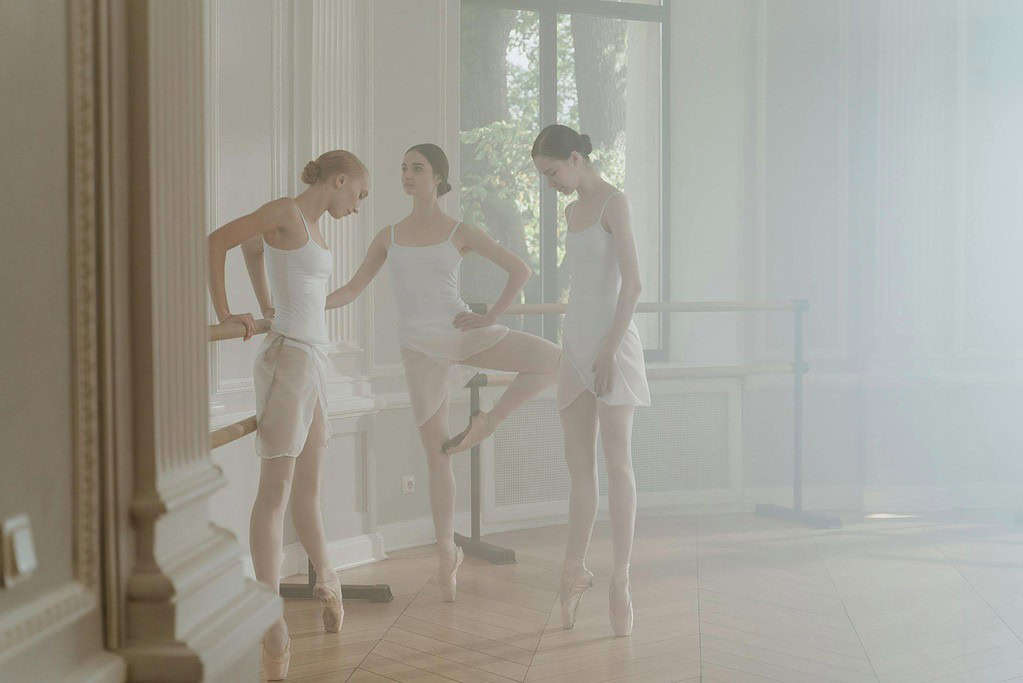 three dancers warming up before dance class