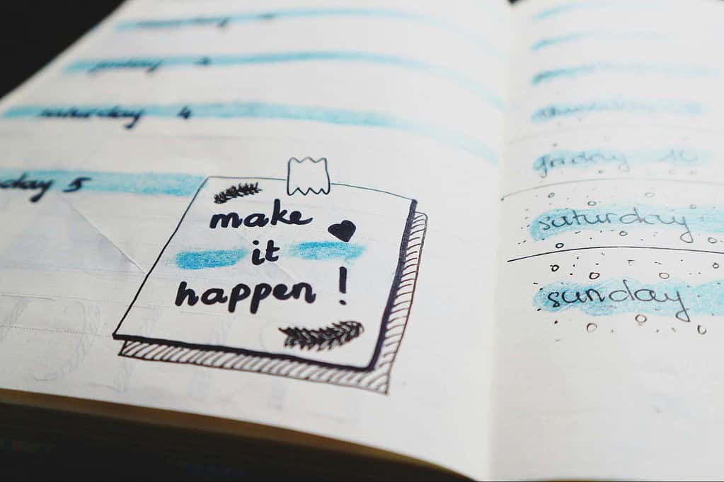 Page of a book with a note 'make it happen!'