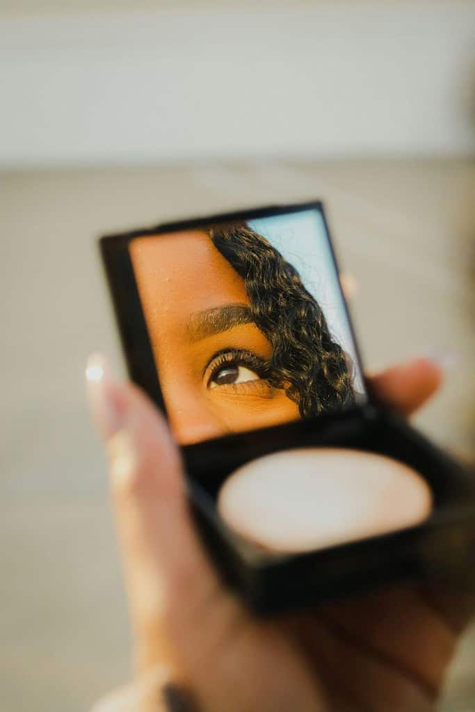 Using a compact mirror for applying makeup