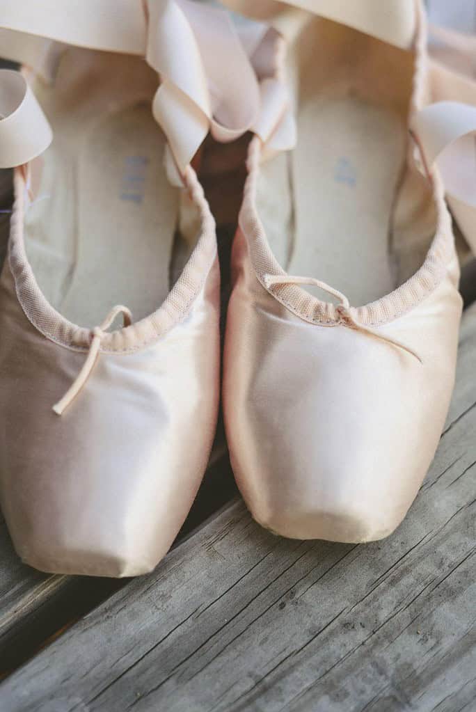 Pointe shoes displayed on wooden floor