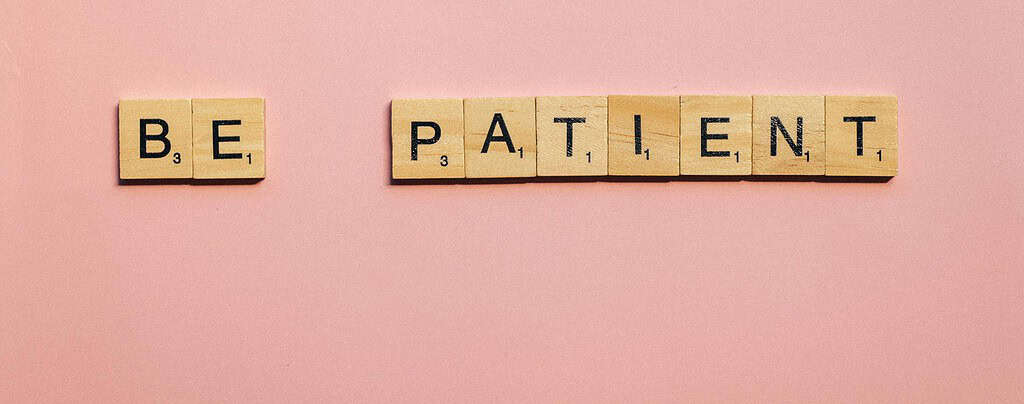 Be Patient scrabble pieces against a pink backdrop