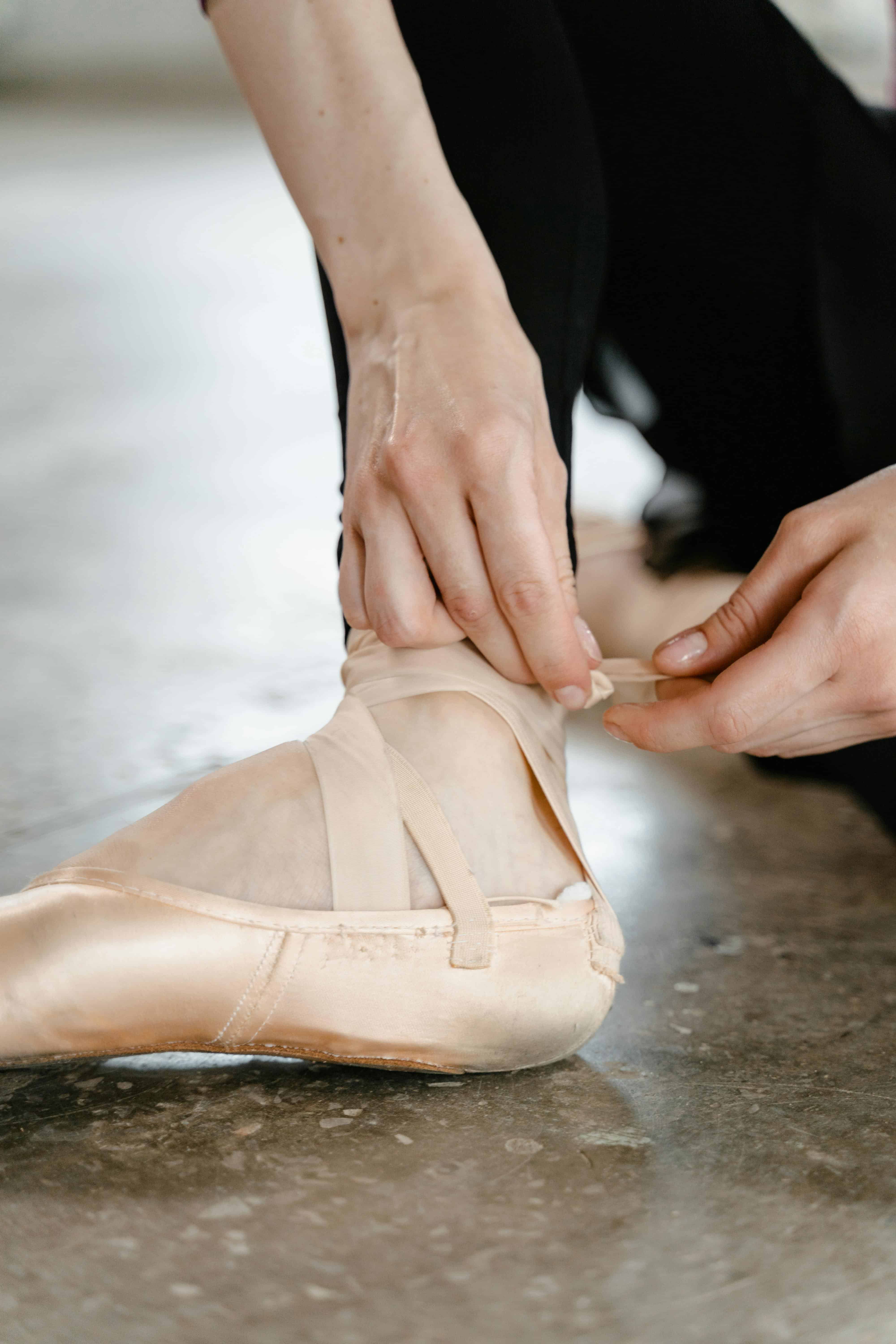 Dancer putting on her pointe shoe