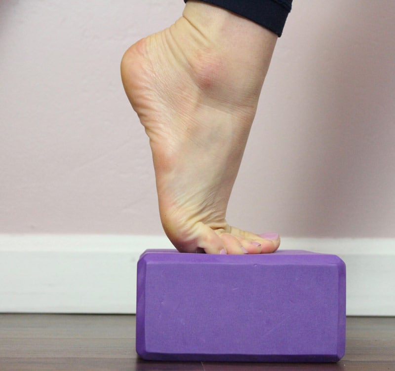 Dancer standing on a purple yoga block