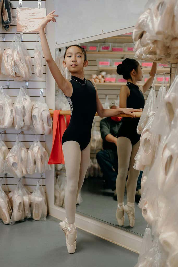 Young dancer trying on pointe shoes in dancewear store