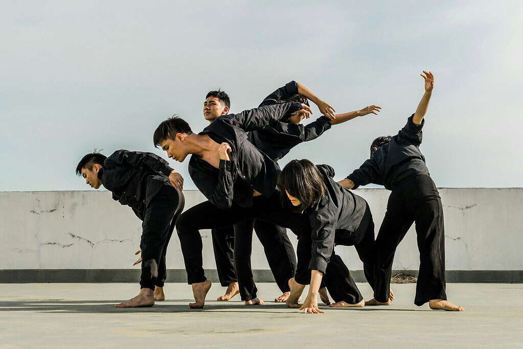 Male dancers performing outside in black outfits