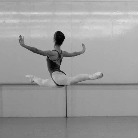 Laura Moreno performing high ballet jump in studio