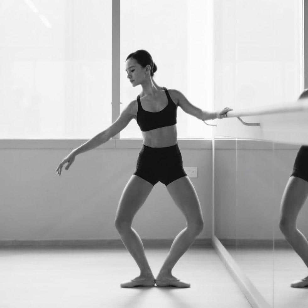 Dancer performing a plie at the barre