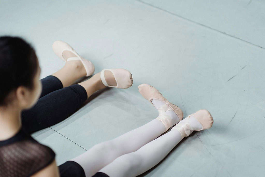 Dancers practising ballet turnout using floor barre