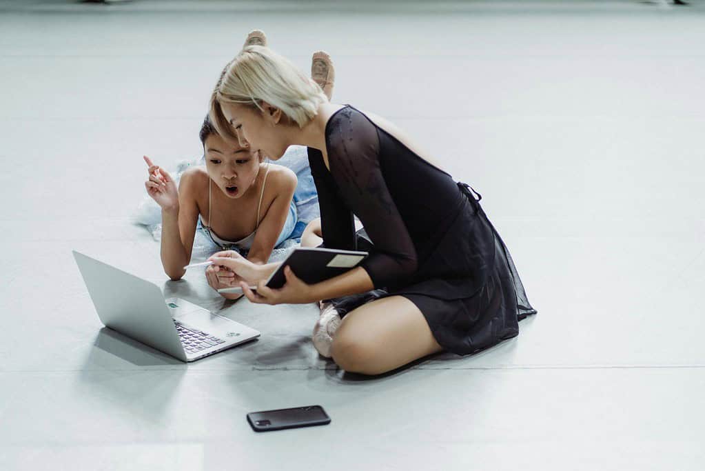 Dance teacher and student watching video recording