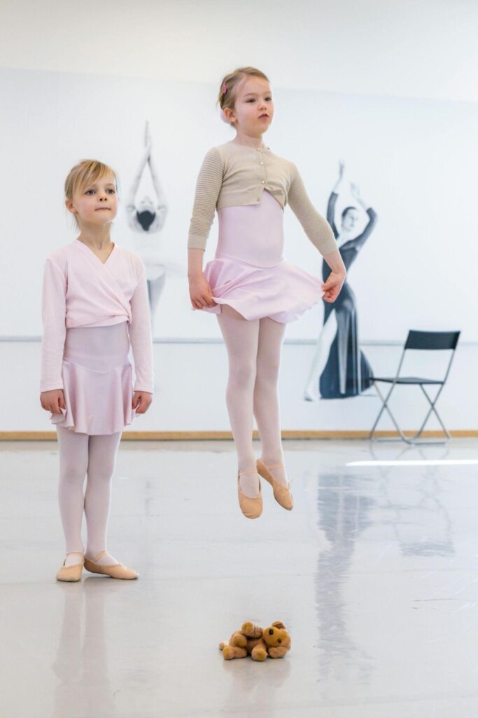 Young dancer performing a ballet saute during class