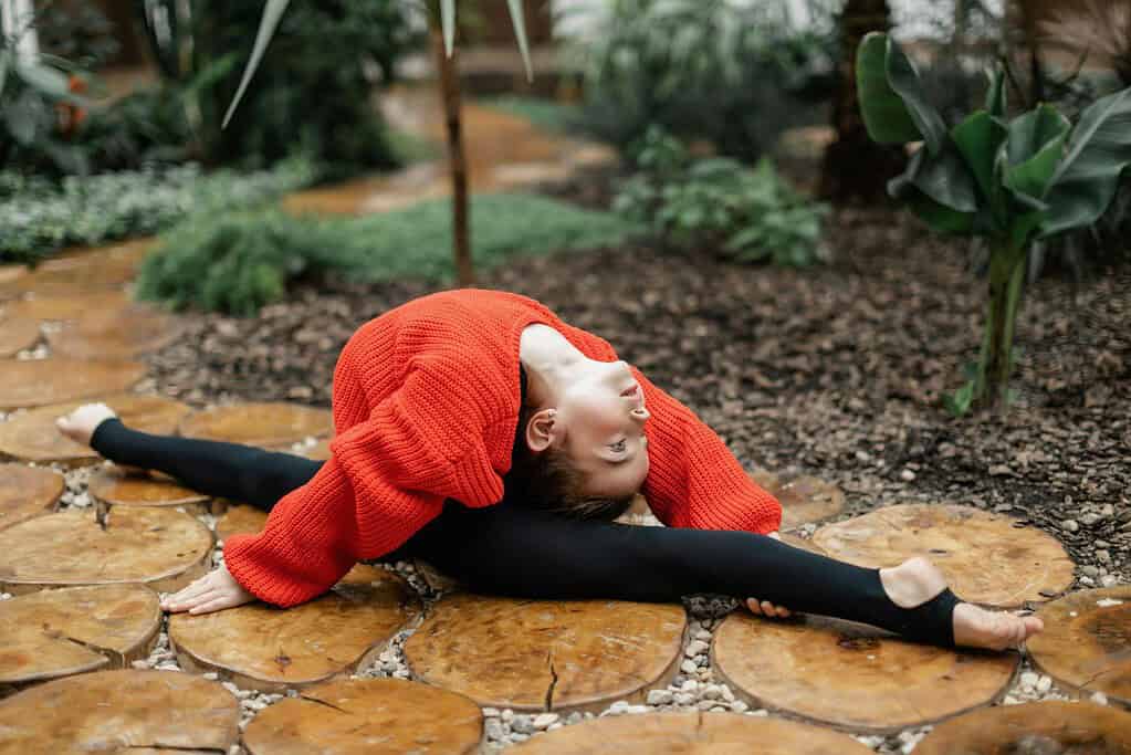 Dancer performing front ballet splits outside