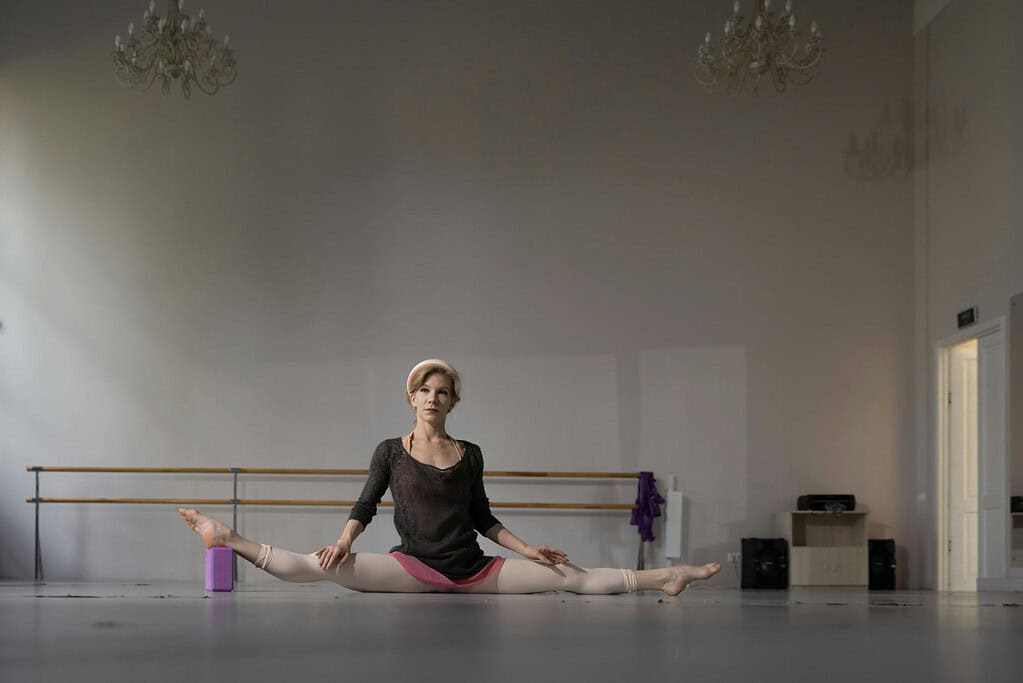 Dancer doing middle splits with a yoga block