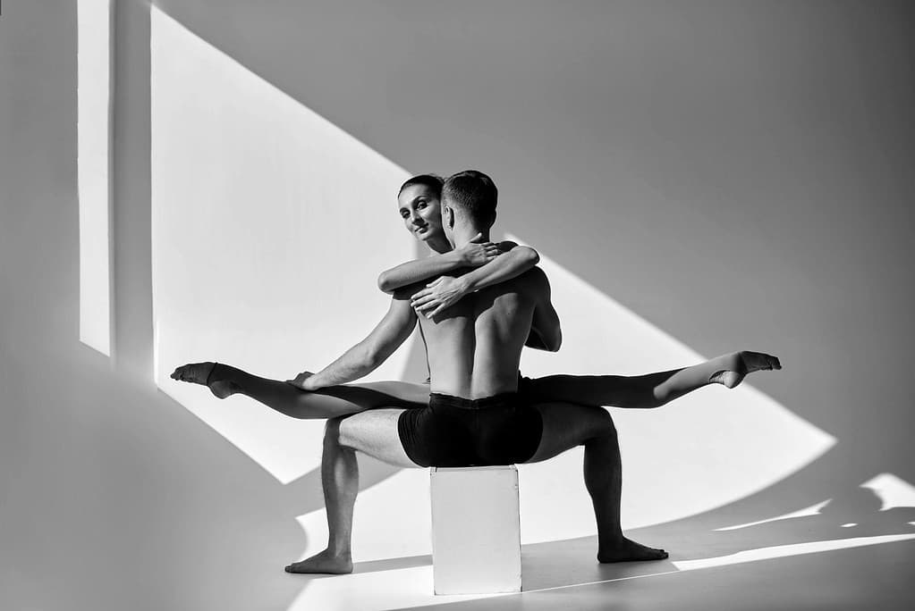 Dancer performing middle splits with partner